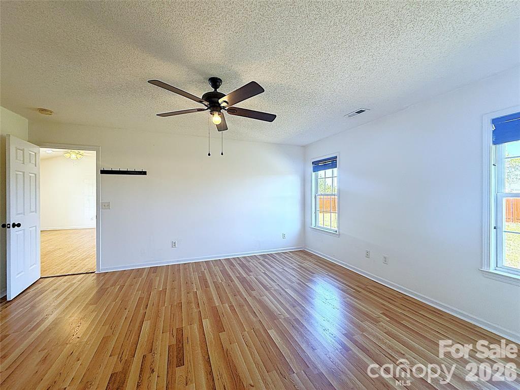 7456 Courtney Pines Road Wilmington, NC 28411 - Photo 16 of 16 a view of empty room with wooden floor and fan