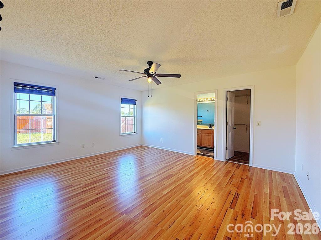 7456 Courtney Pines Road Wilmington, NC 28411 - Photo 7 of 16 a view of a room with wooden floor ceiling fan and windows