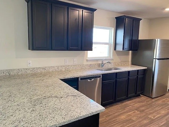 521 Locksley Cove Jarrell, TX 76537 - Photo 8 of 9 a kitchen with stainless steel appliances granite countertop wooden cabinets a refrigerator and sink