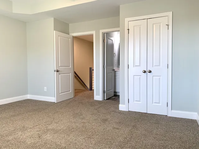 an empty room with closet and a bathroom