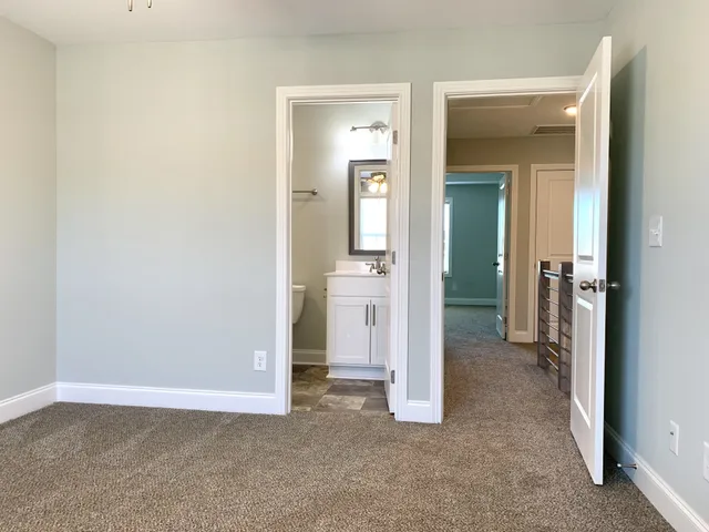 an empty room with closet and a bathroom
