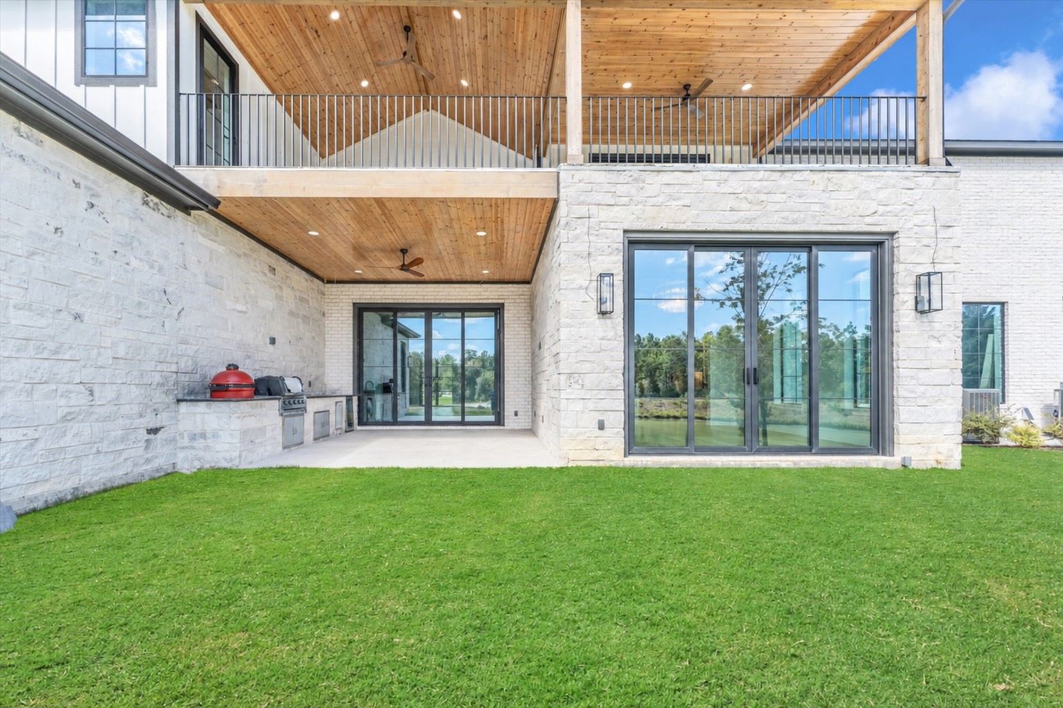 23701 Birch Grove Road Montgomery, TX 77316 - Photo 46 of 50 Discover the perfect blend of luxury and relaxation with this stunning property's expansive patio, complete with a built-in grill and lush green views.