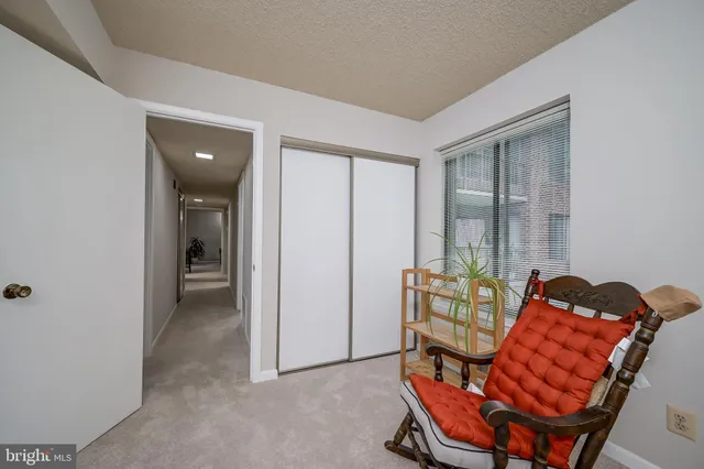 a living room with furniture a rug and white walls