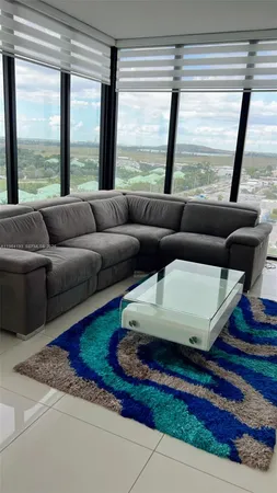 a living room with furniture and large windows
