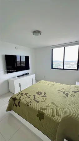 a bedroom with a bed and a flat screen tv