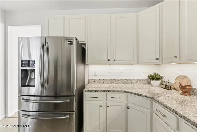 a kitchen with appliances a refrigerator and cabinets