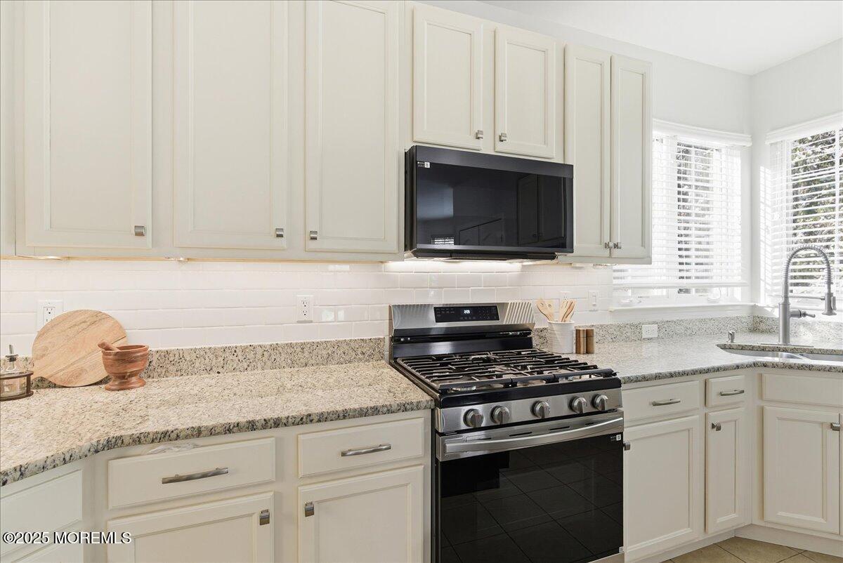 10 Sunshine Way Jackson, NJ 08527 - Photo 12 of 50 a kitchen with granite countertop white cabinets and a stove
