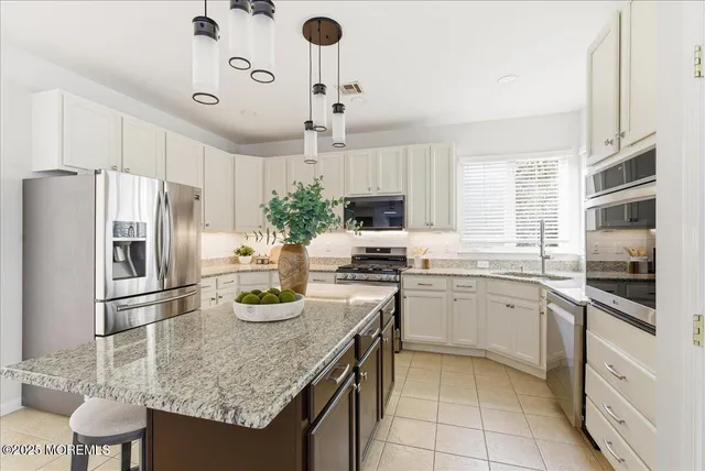 a kitchen with granite countertop stainless steel appliances a sink stove and refrigerator