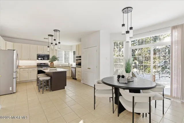 a kitchen with a dining table chairs and refrigerator