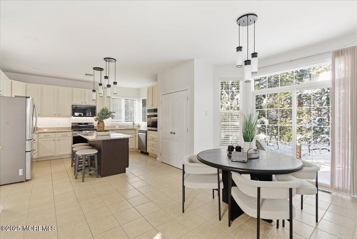 10 Sunshine Way Jackson, NJ 08527 - Photo 14 of 50 a kitchen with a dining table chairs and refrigerator