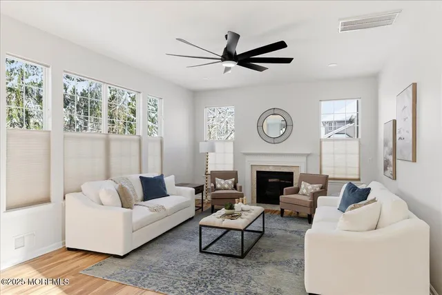 a living room with furniture a fireplace and a large window