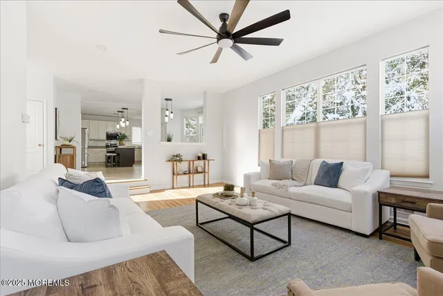a living room with furniture and a large window with wooden floor