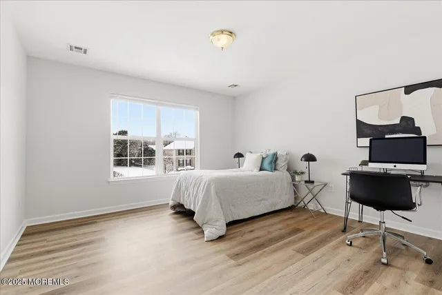 a spacious bedroom with a bed window and table