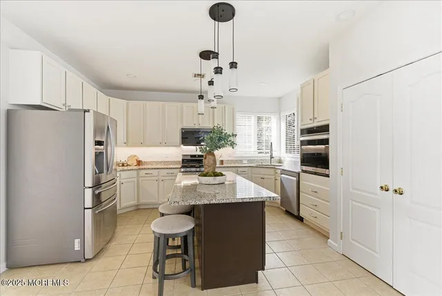 a kitchen with stainless steel appliances a refrigerator a stove a sink dishwasher and a refrigerator with wooden floor