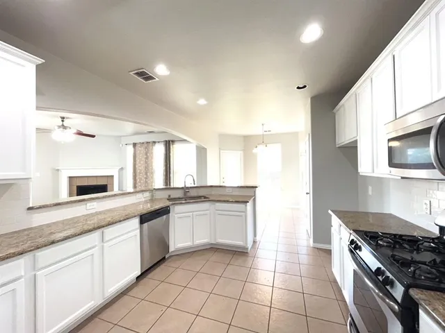 a kitchen with a sink stove top oven and cabinets
