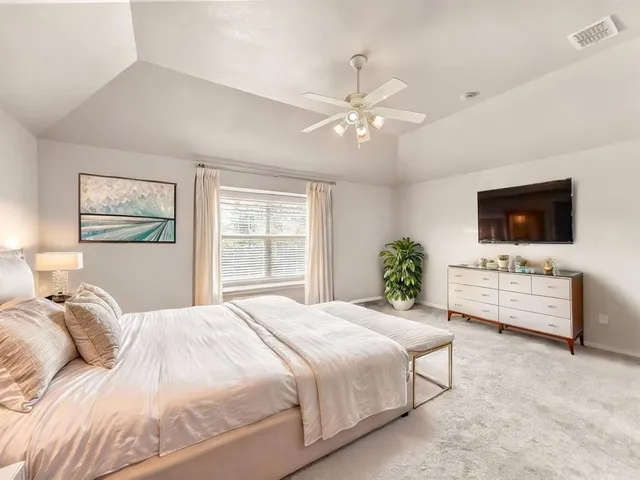 a bedroom with a bed window and a flat screen tv