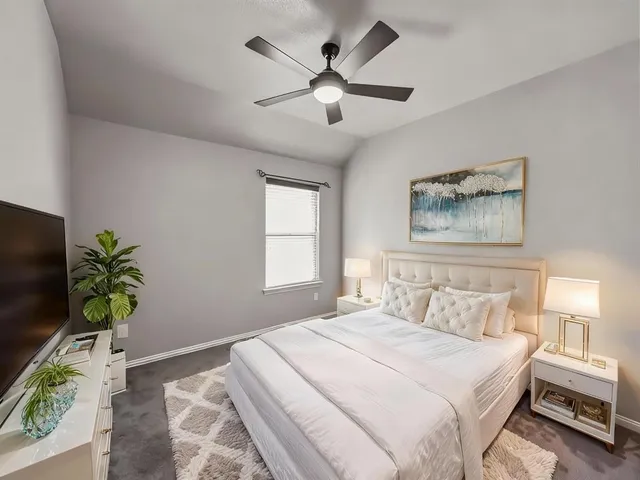 a bedroom with a large bed and a chandelier