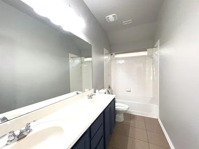 a bathroom with a tub sink and mirror