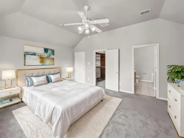 a spacious bedroom with a large bed a chandelier and closet