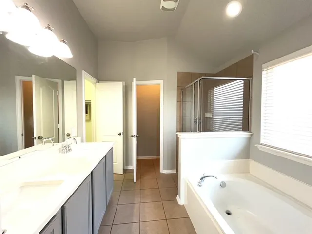 a bathroom with a bathtub sink and mirror