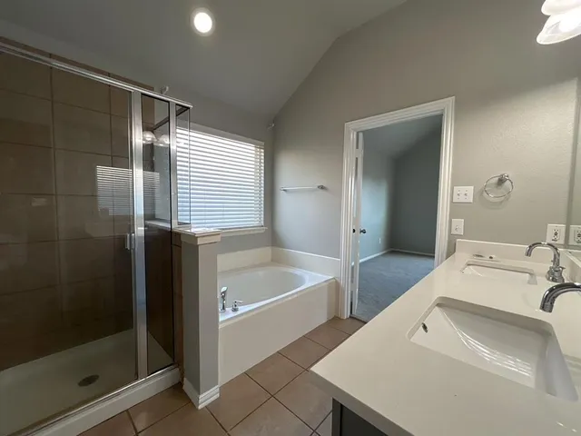 a en suite bathroom with a tub sink and shower