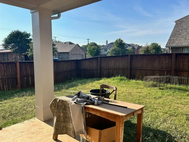 a view of backyard with a tub and trees in the background