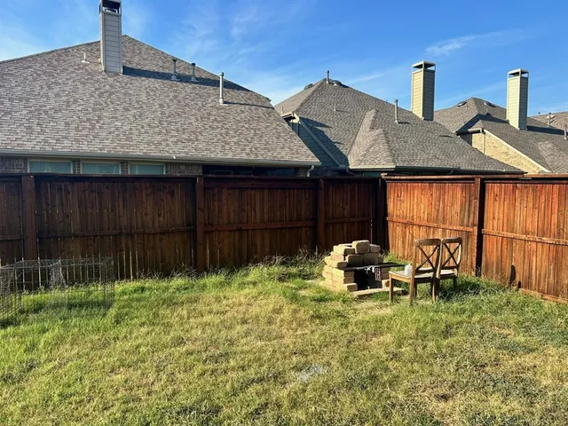 a backyard of a house with table and chairs