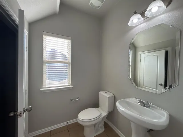 a bathroom with a toilet sink and a mirror