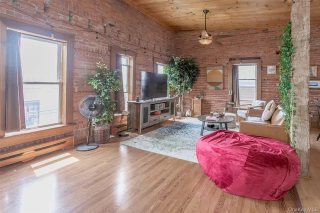 a view of a livingroom with furniture window and wooden floor