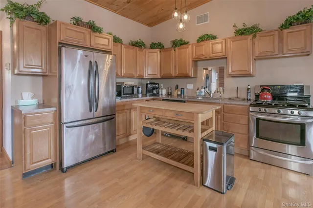 a kitchen with granite countertop a refrigerator stove and white cabinets