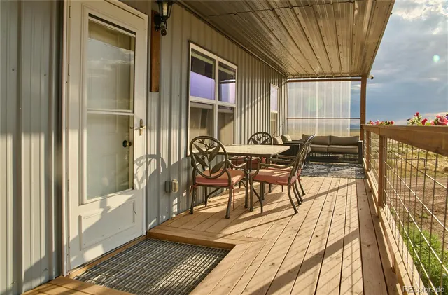 a view of a balcony with chairs and wooden floor