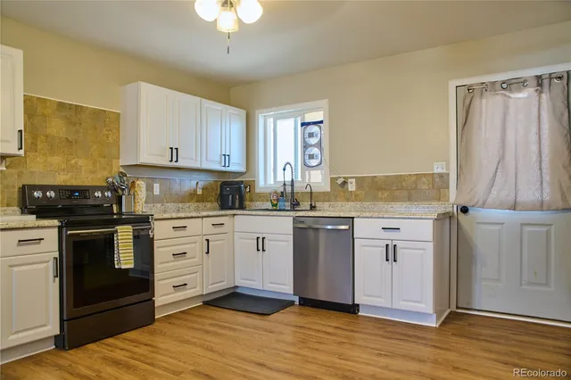 a kitchen with stainless steel appliances granite countertop a stove a sink and a refrigerator