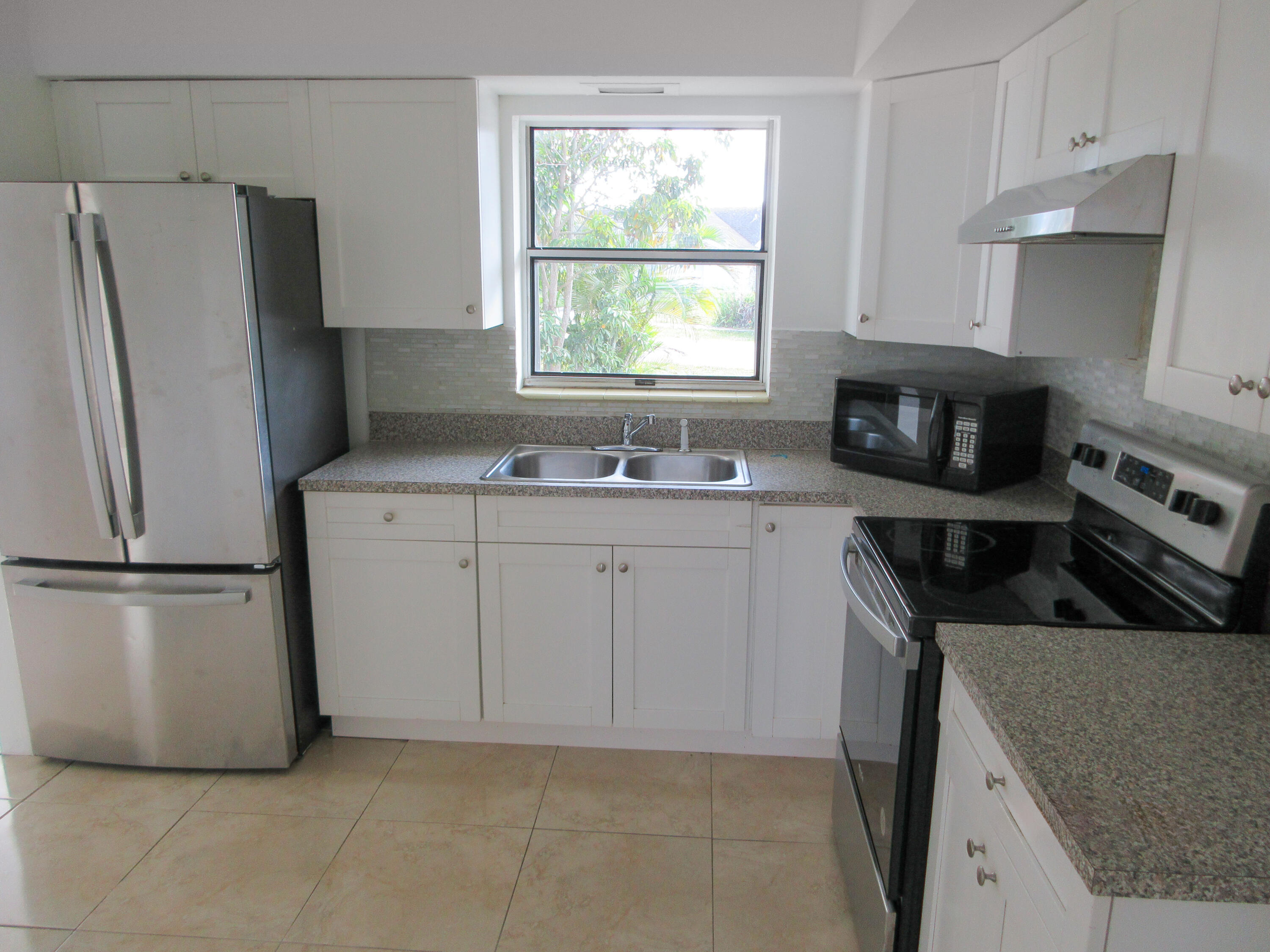 3801 Northwest 6th Street Lauderhill, FL 33311 - Photo 2 of 13 a kitchen with a sink a refrigerator and a stove