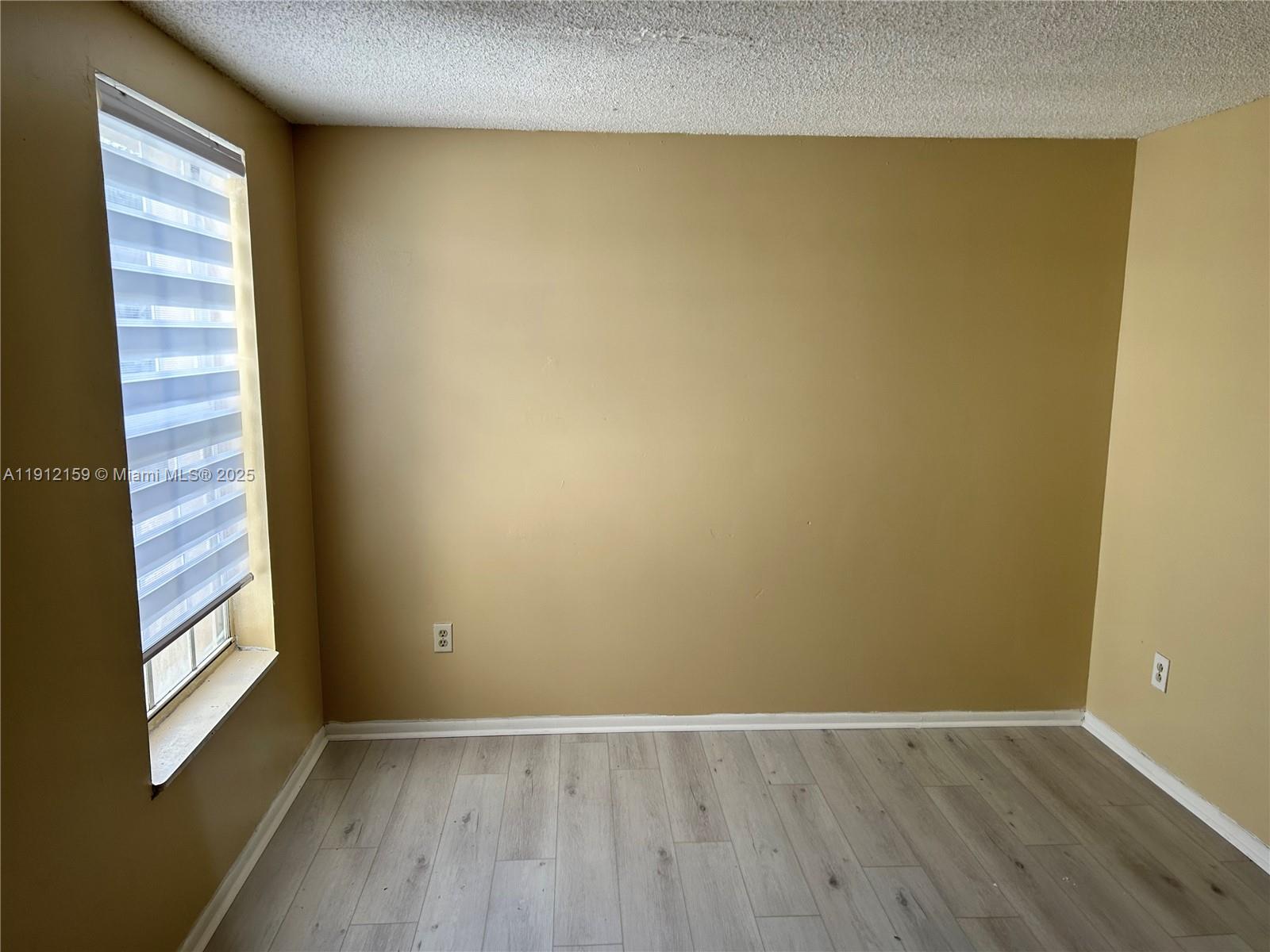 1111 Southwest 84th Terrace Pembroke Pines, FL 33025 - Photo 11 of 11 a view of an empty room with wooden floor and a window