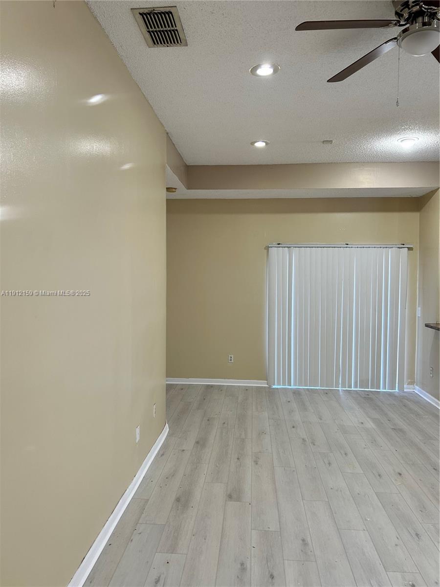 1111 Southwest 84th Terrace Pembroke Pines, FL 33025 - Photo 5 of 11 an empty room with wooden floor and windows