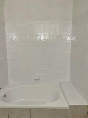 a view of an empty room with wooden floor and closet