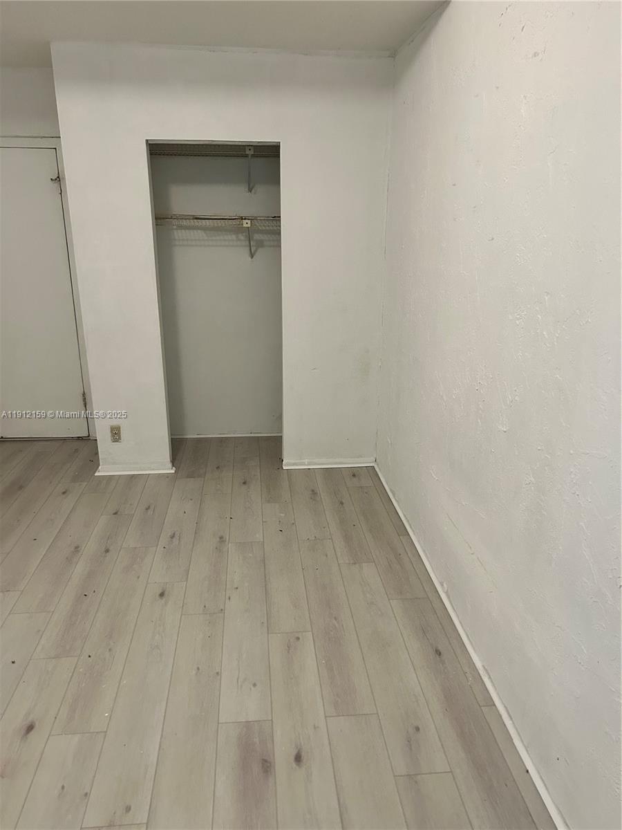 1111 Southwest 84th Terrace Pembroke Pines, FL 33025 - Photo 9 of 11 a view of an empty room with wooden floor and closet