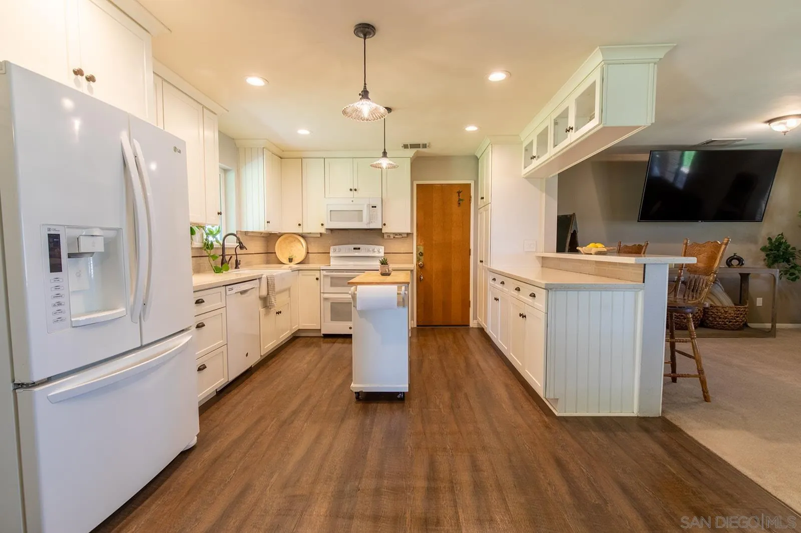 5754 Brandt Road Brawley, CA 92227 - Photo 24 of 48 a kitchen with stainless steel appliances a refrigerator a sink dishwasher a stove top oven a dining table and chairs with wooden floor