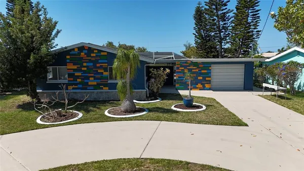 a front view of a house with garden and plants