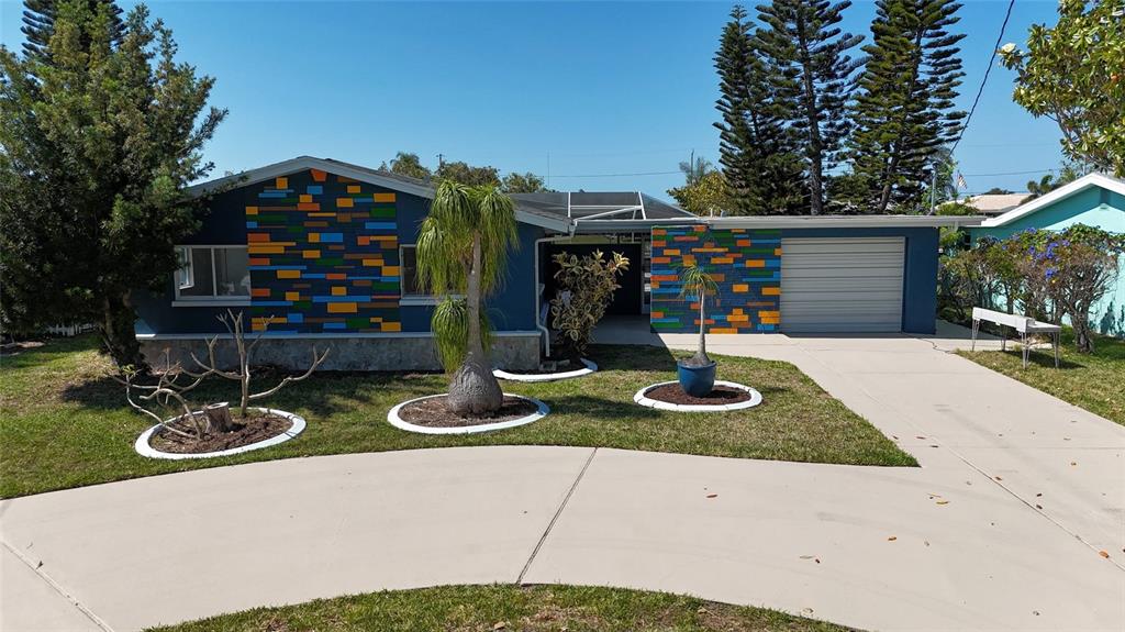 a front view of a house with garden and plants