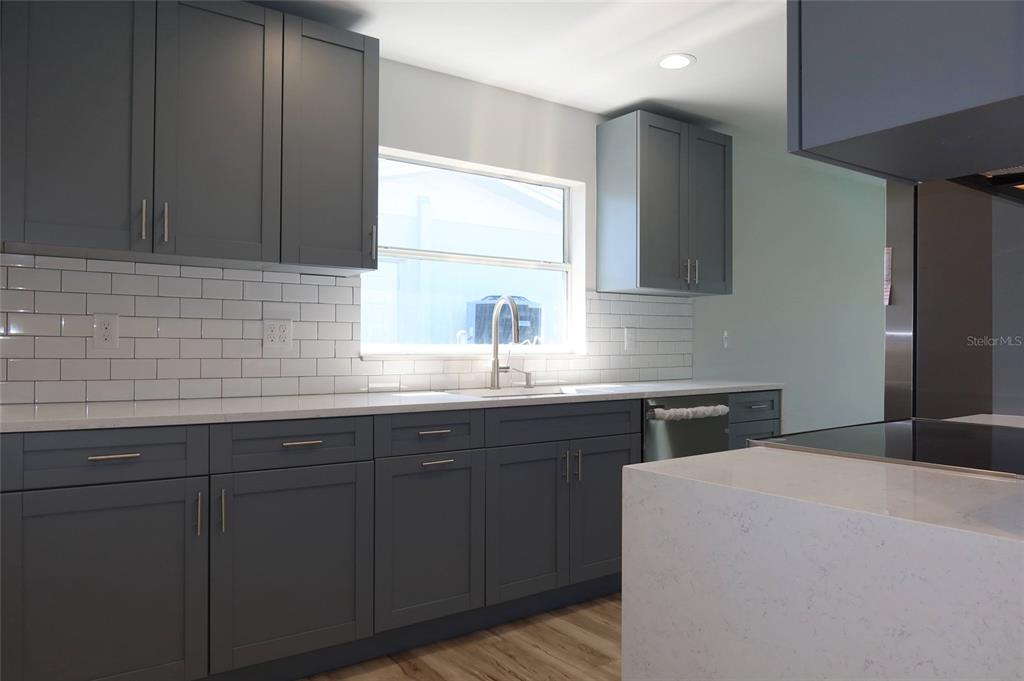 4240 Floramar Terrace New Port Richey, FL 34652 - Photo 11 of 51 a kitchen with a sink cabinets and wooden floor