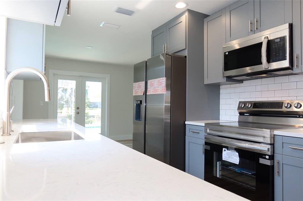 4240 Floramar Terrace New Port Richey, FL 34652 - Photo 12 of 51 a kitchen with a refrigerator microwave and sink