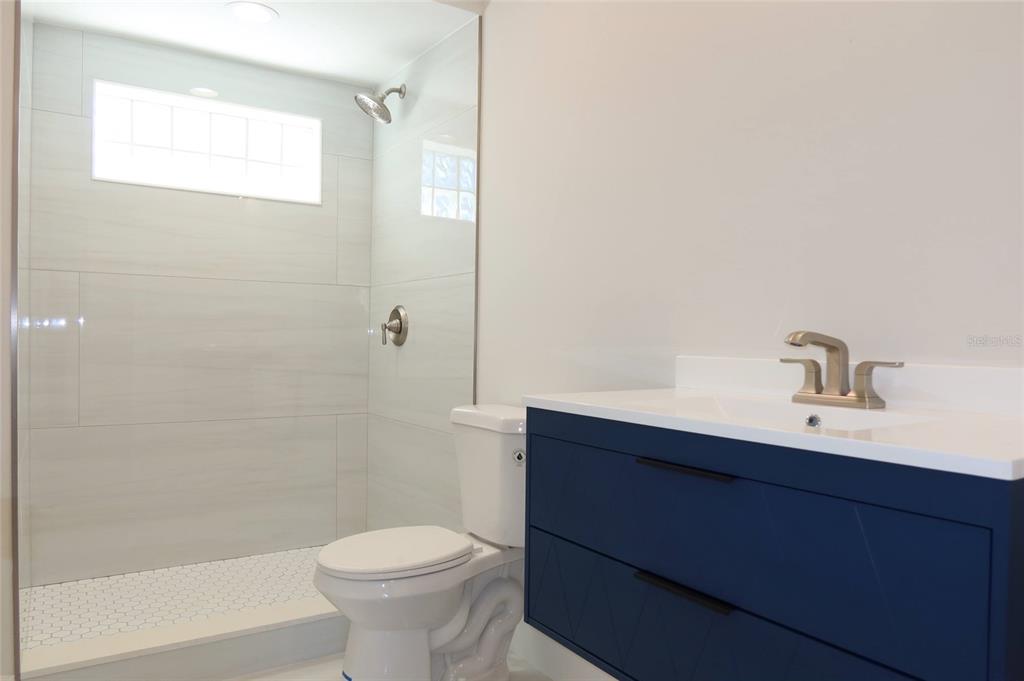 4240 Floramar Terrace New Port Richey, FL 34652 - Photo 14 of 51 a bathroom with a sink a toilet and shower