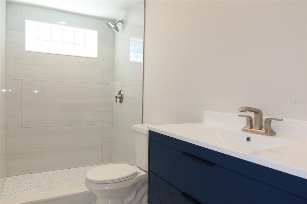 4240 Floramar Terrace New Port Richey, FL 34652 - Photo 16 of 51 a bathroom with a sink a toilet and shower
