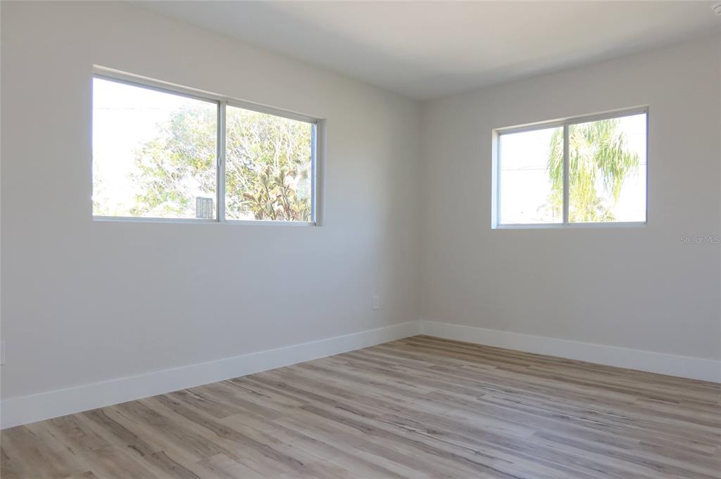 4240 Floramar Terrace New Port Richey, FL 34652 - Photo 19 of 51 an empty room with wooden floor and windows