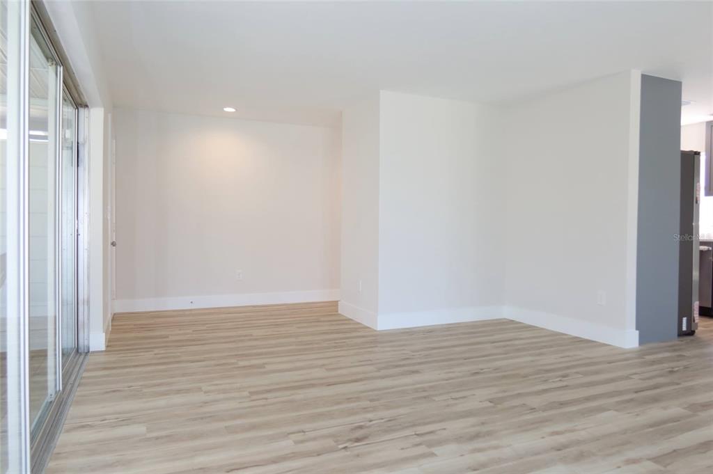 4240 Floramar Terrace New Port Richey, FL 34652 - Photo 24 of 51 a view of an empty room with wooden floor and a window