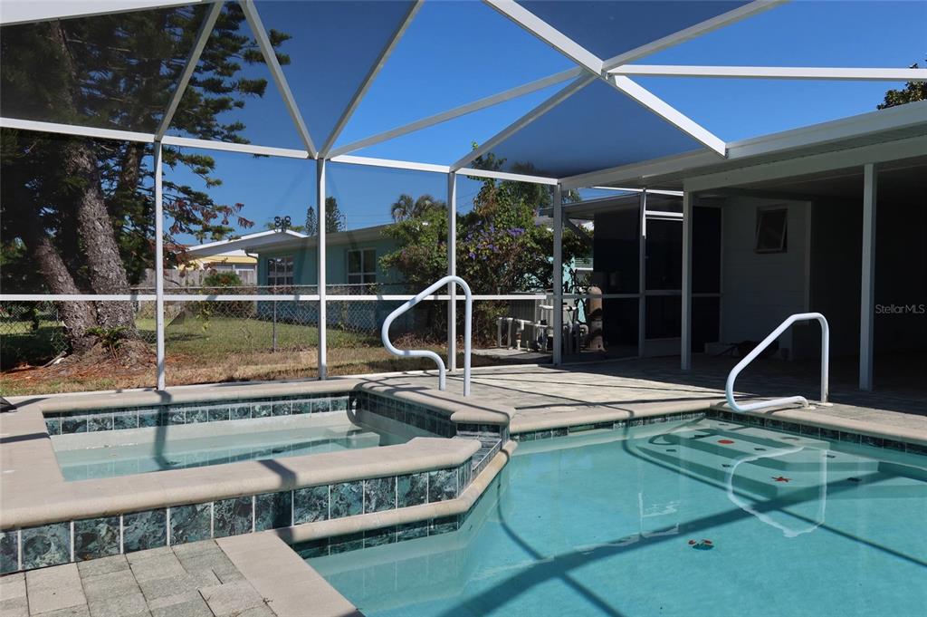 4240 Floramar Terrace New Port Richey, FL 34652 - Photo 26 of 51 a view of a swimming pool with a patio and a garden