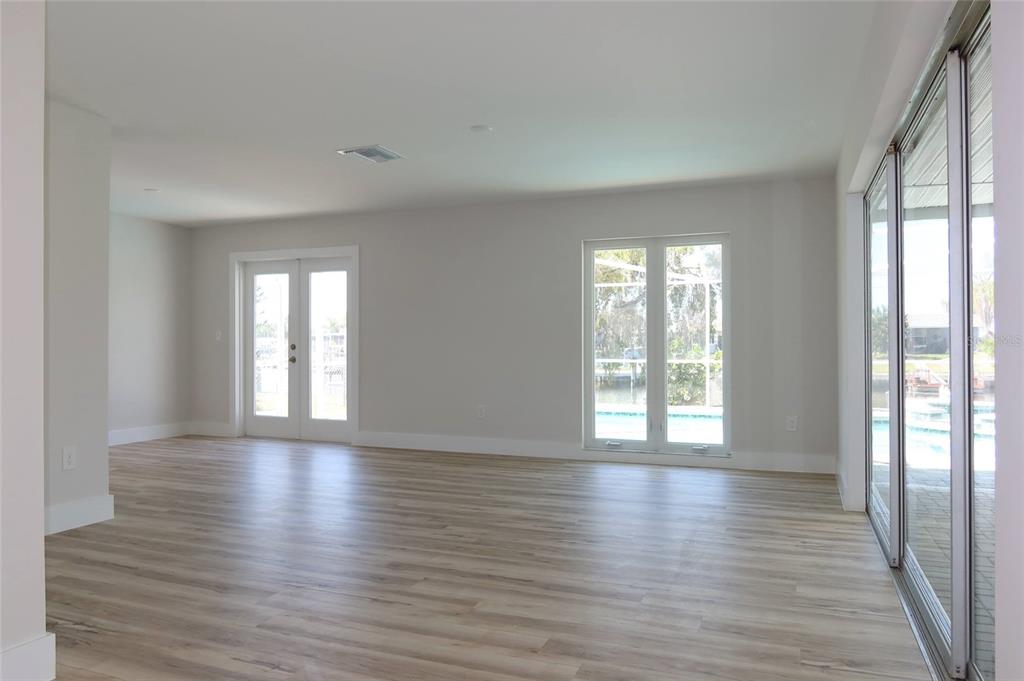 4240 Floramar Terrace New Port Richey, FL 34652 - Photo 4 of 51 a view of an empty room with wooden floor and a window