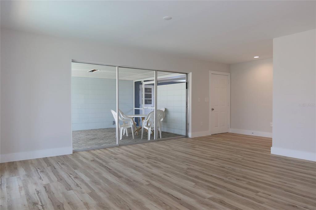 4240 Floramar Terrace New Port Richey, FL 34652 - Photo 6 of 51 a view of a room with wooden floor and chairs