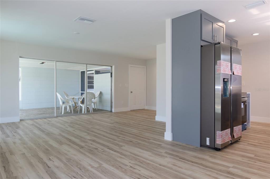 4240 Floramar Terrace New Port Richey, FL 34652 - Photo 7 of 51 a view of a kitchen with a refrigerator and wooden floor